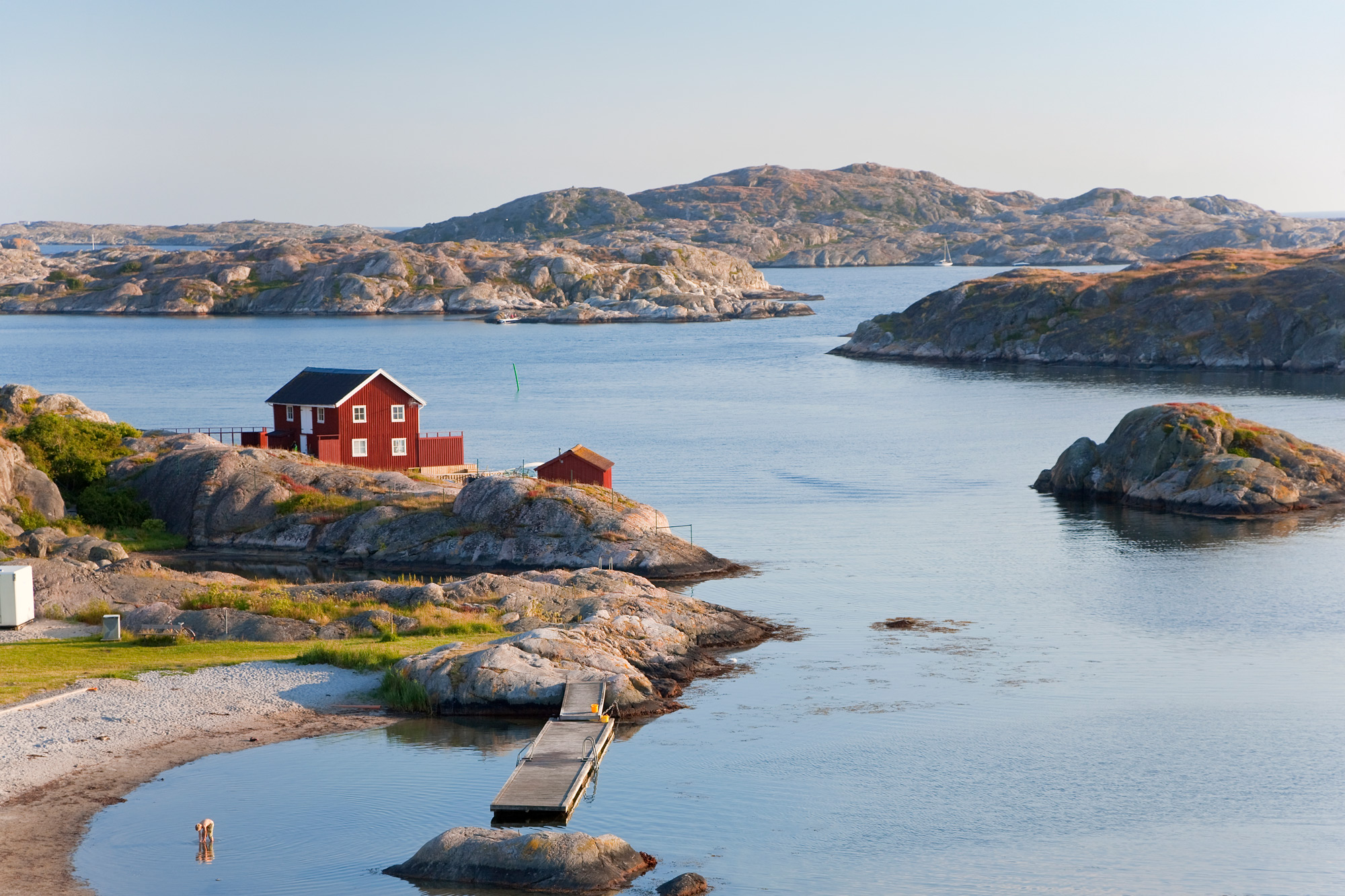 En röd stuga placerad precis vid havet